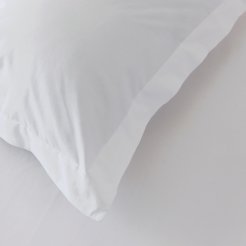 A close up of the corner of a white pillow