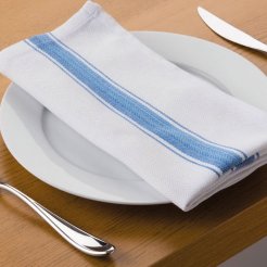 A white table set with silverware and a white serviette with a blue stripe